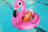 A baby is sitting happily in a pink flamingo floaty, wearing a mango orange Infant Warm Belly Wetsuit and a pink striped sunhat. 